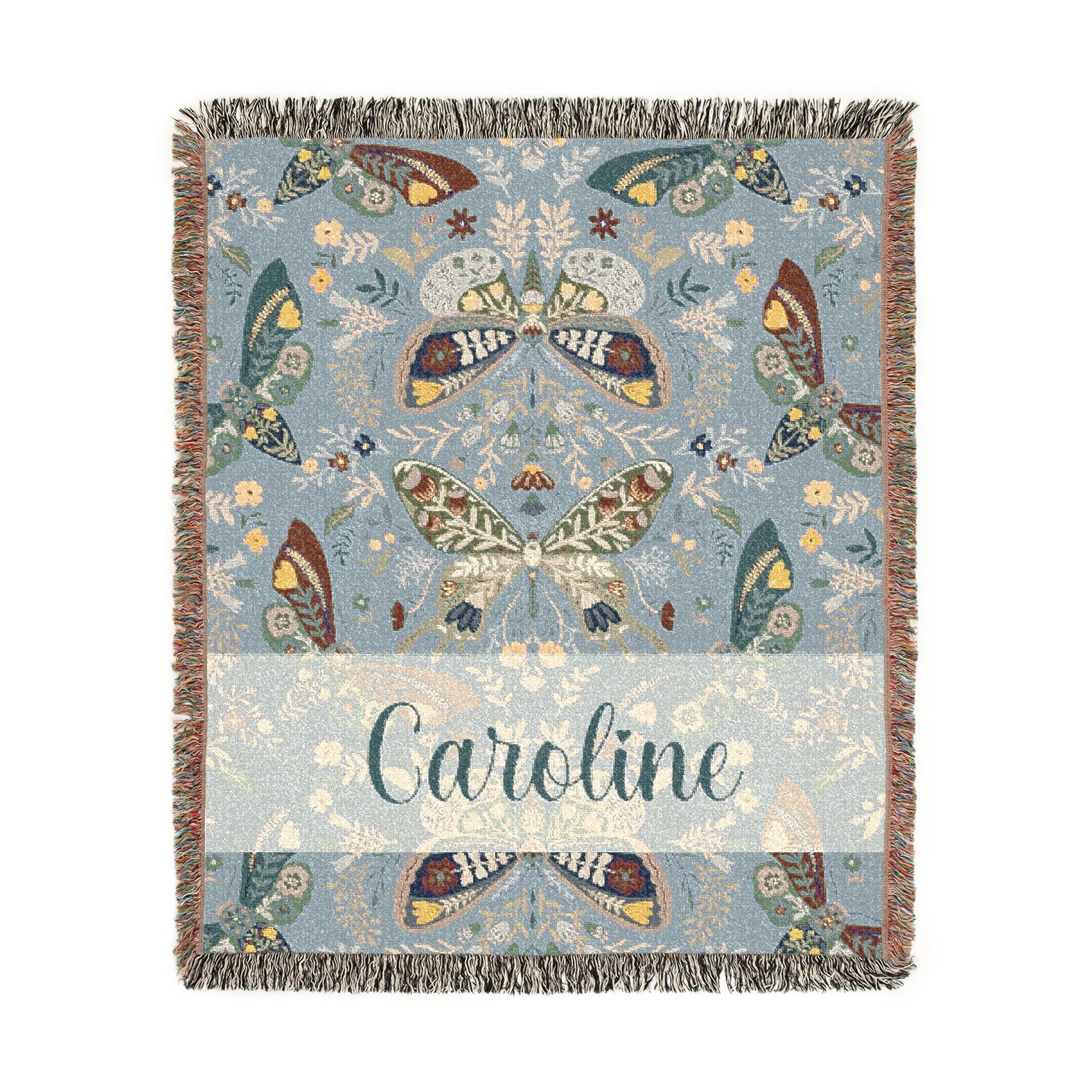 Decorative blanket with butterfly pattern and 'Caroline' text on a light blue background
