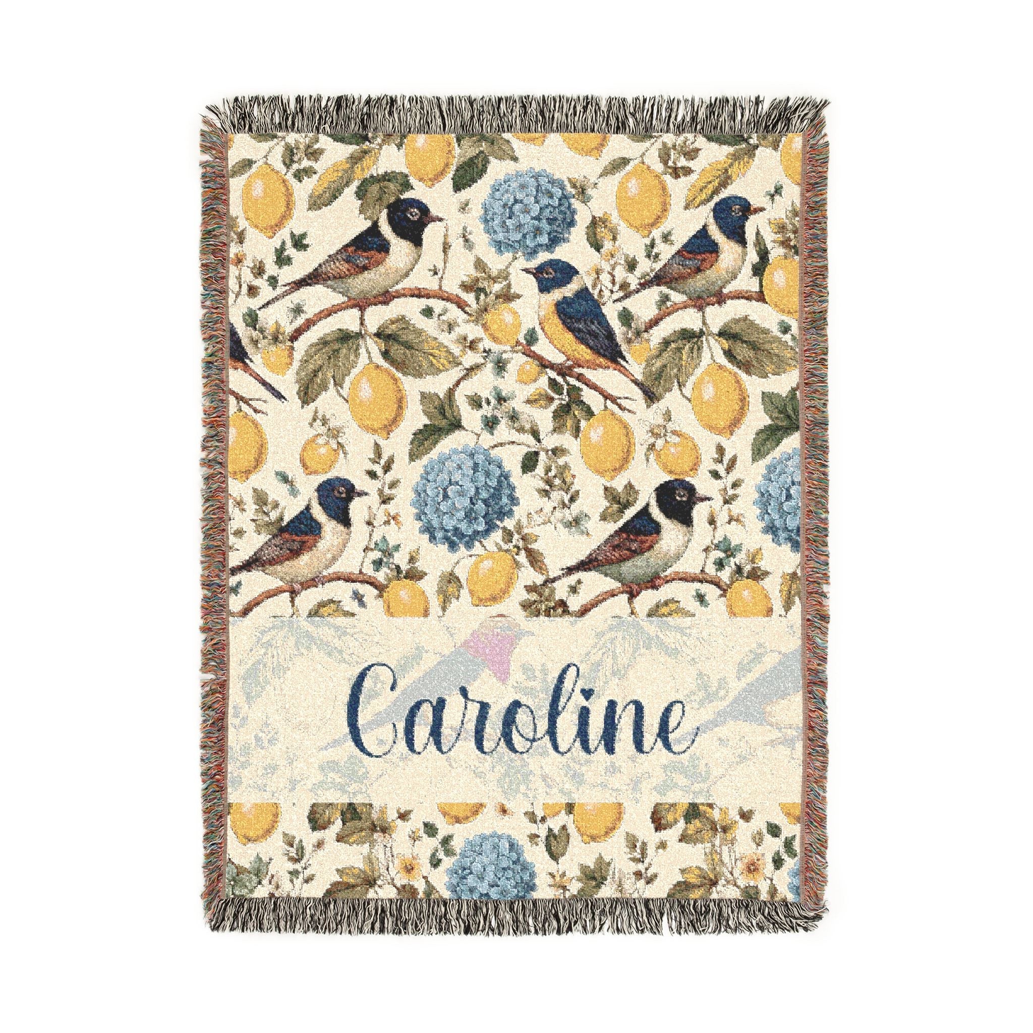 Decorative blanket with floral and bird pattern and the name 'Caroline' on a white background