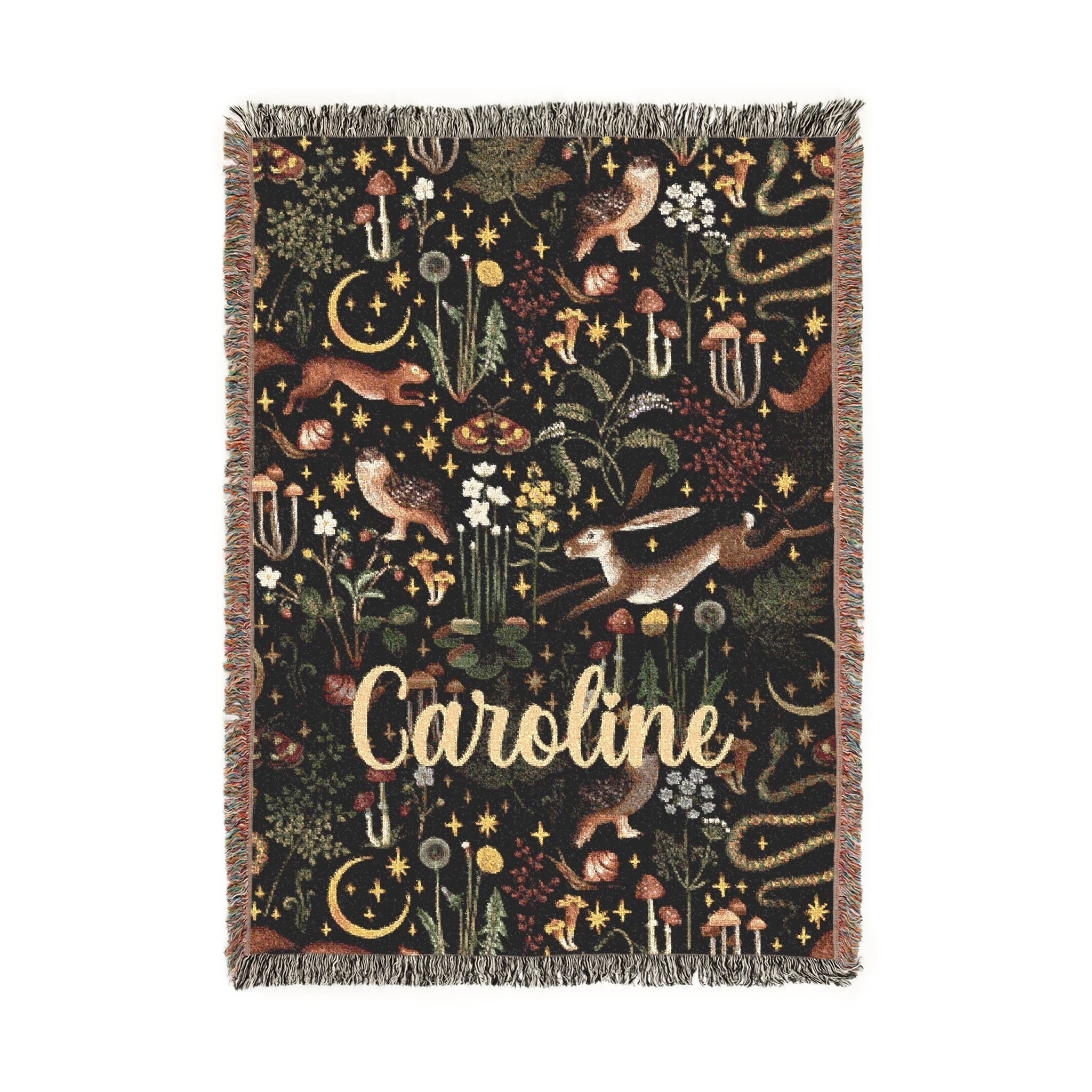 Decorative blanket with nature-themed design and 'Caroline' text on a white background