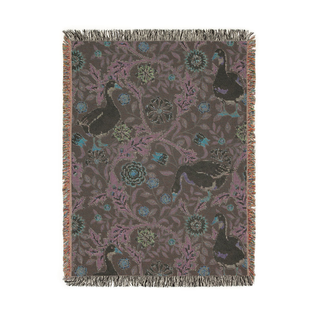 Decorative throw blanket with animal and floral pattern on a plain background