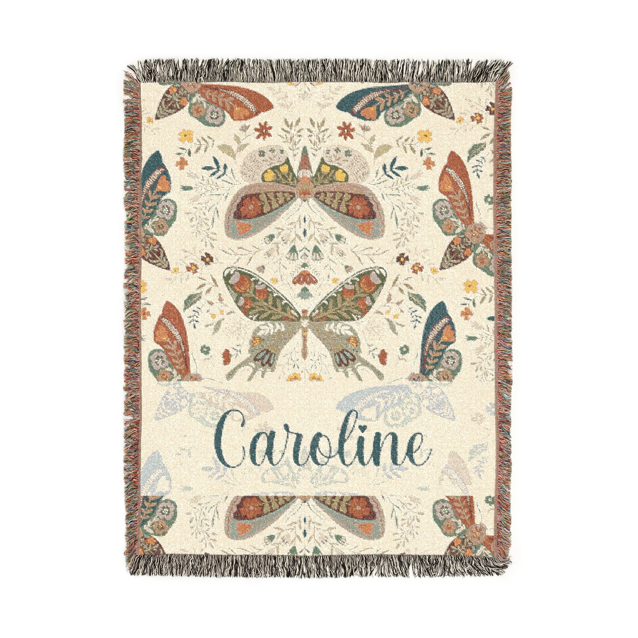 Decorative throw blanket with butterfly patterns and the name 'Caroline' on a white background