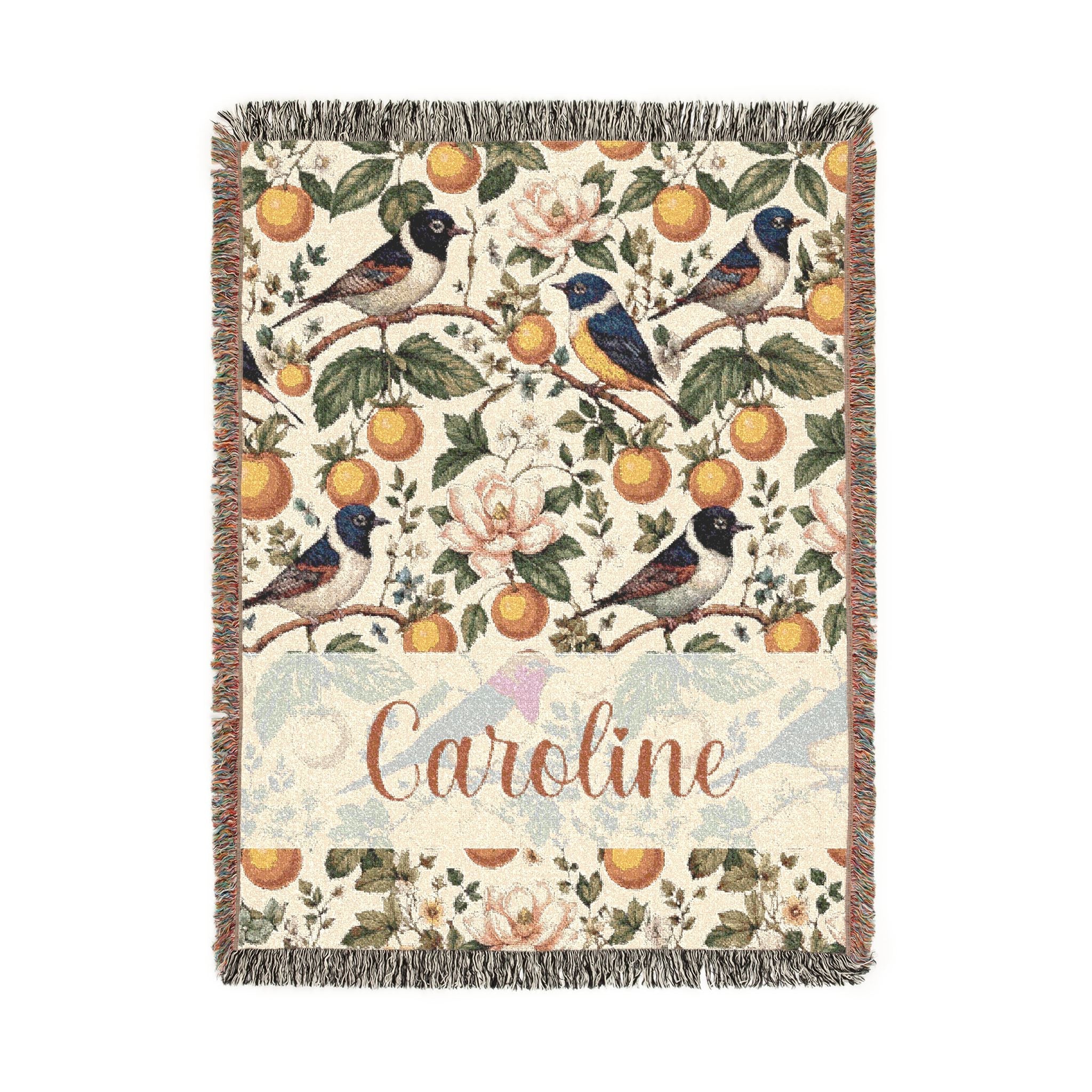 Decorative blanket with birds, flowers, and oranges pattern and the name 'Caroline'.