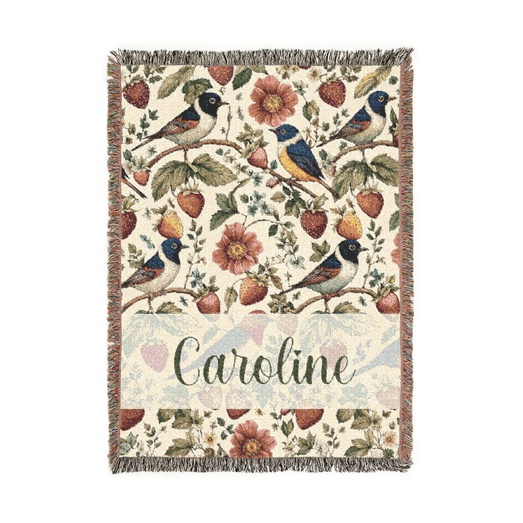 Decorative blanket with floral and bird pattern and 'Caroline' text on a white background