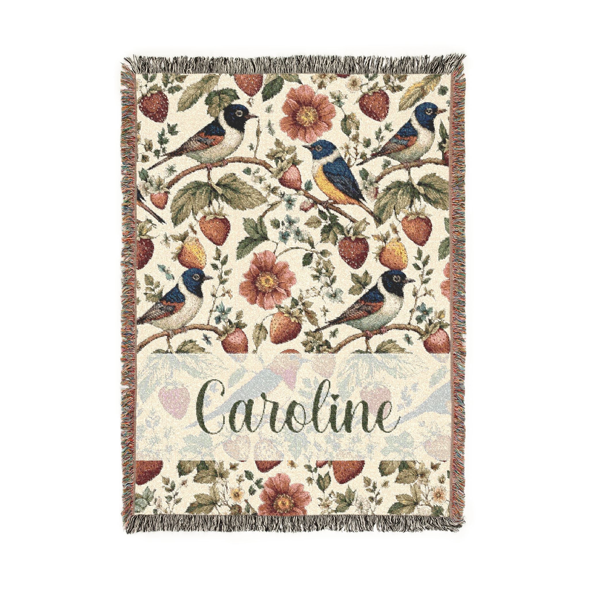 Decorative blanket with floral and bird pattern and 'Caroline' text on a white background