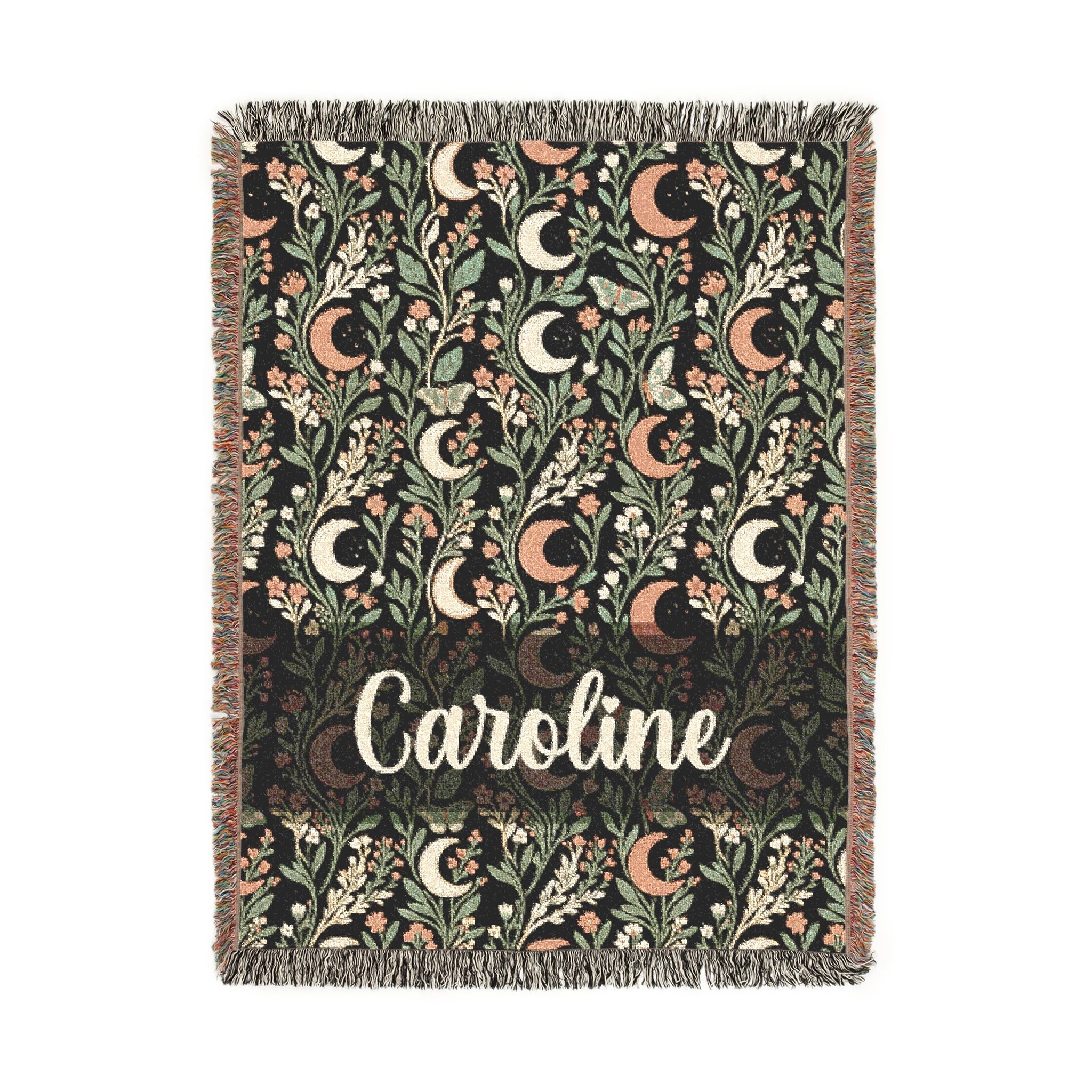 Decorative throw blanket with floral patterns and the name 'Caroline' on a white background