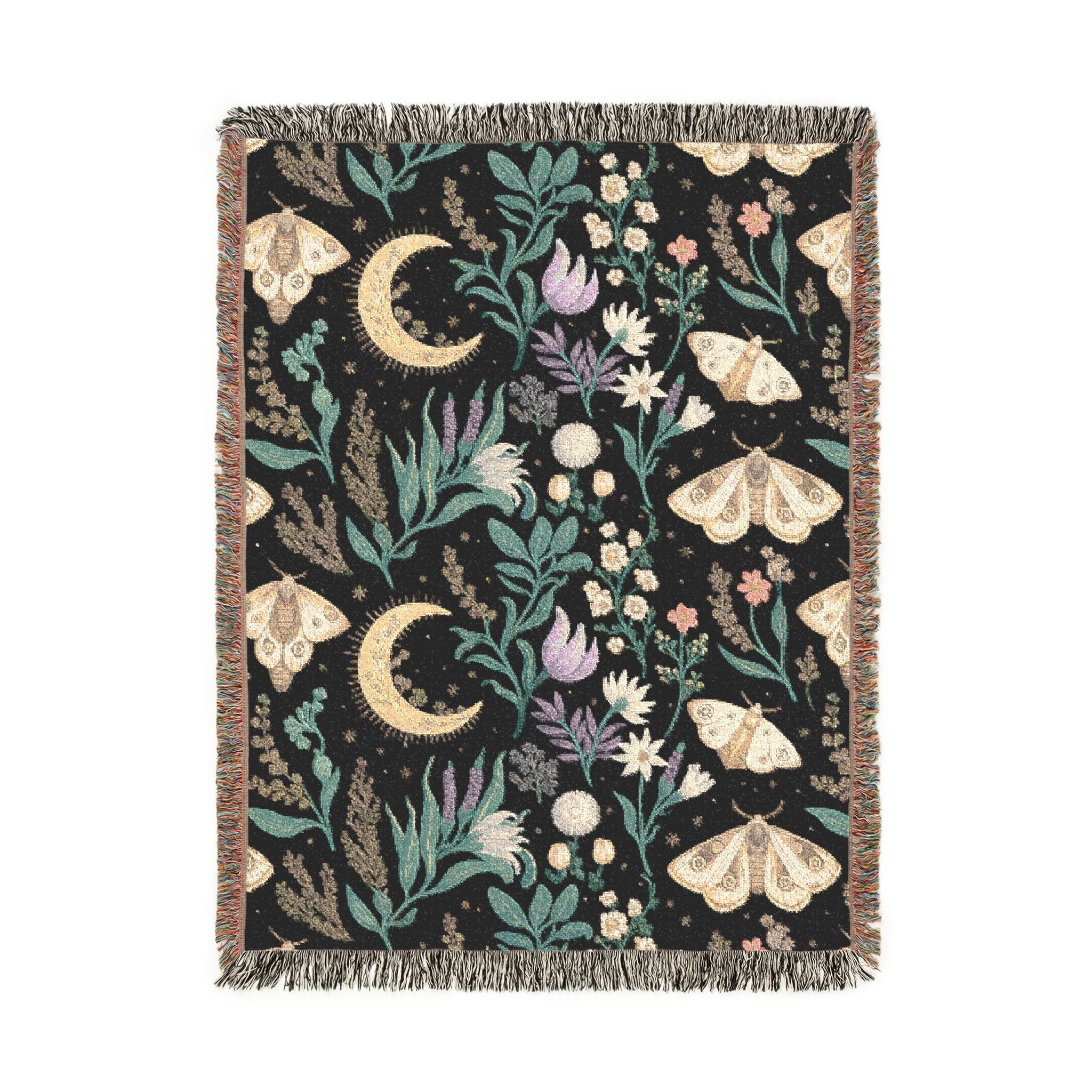Decorative throw blanket with moon, butterfly, and floral patterns on a black background