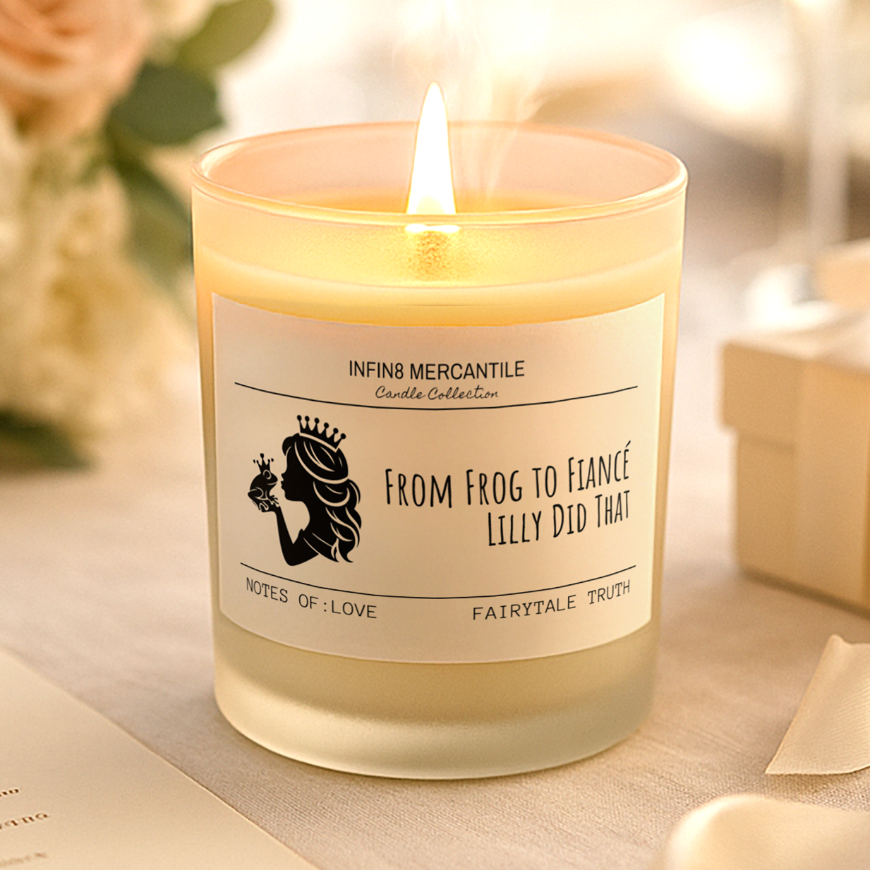 Candle with a label on a table with flowers and a gift box in the background