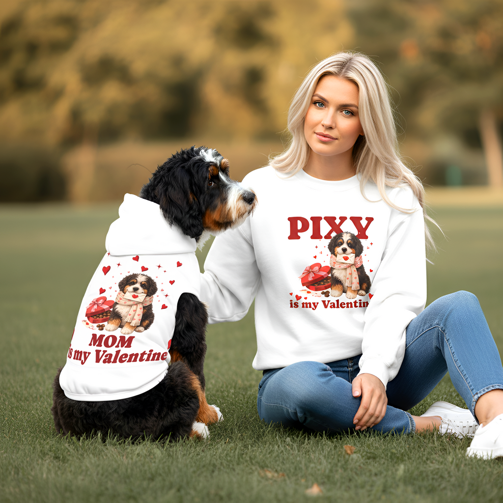 Woman and dog wearing Valentine-themed shirts in a park setting